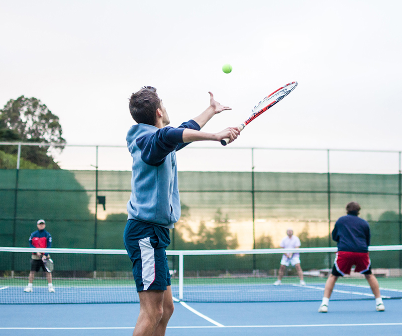 man serving tennis ball